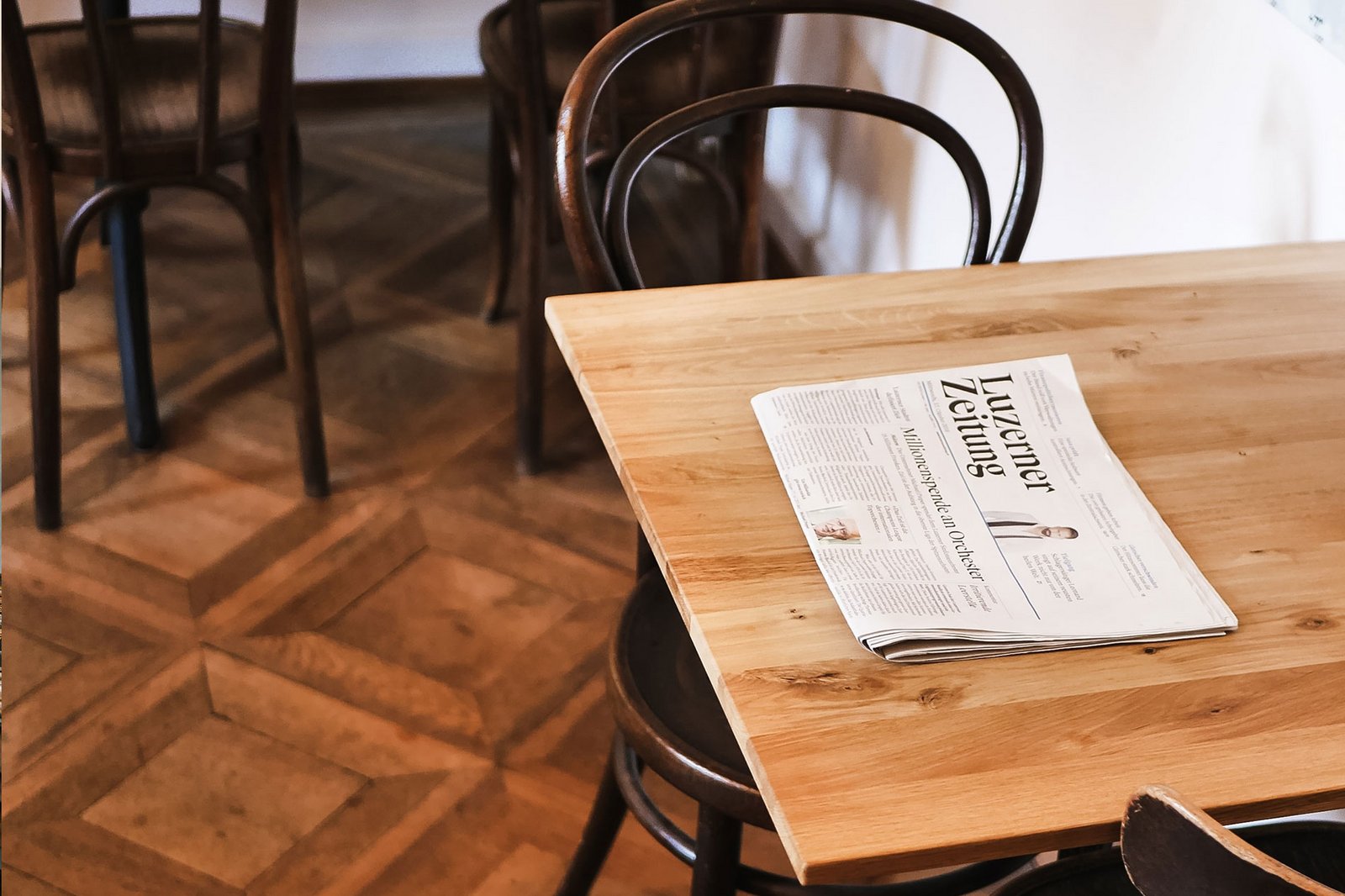 Un exemplaire du journal "Luzerner Zeitung" est posé sur une table de bistrot. 